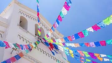 Multi-colored flags flying outside of building